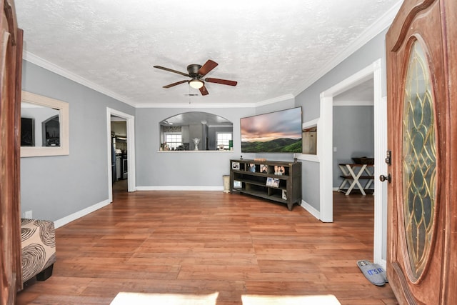 living room featuring ceiling fan, crown molding, and a textured ceiling