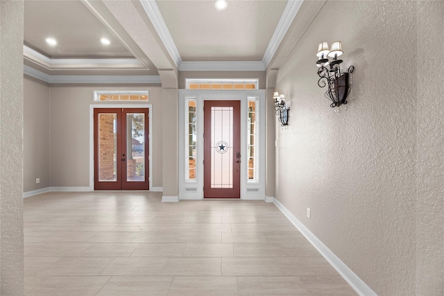 foyer with crown molding, a wealth of natural light, and french doors