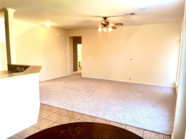 unfurnished room with light colored carpet and ceiling fan