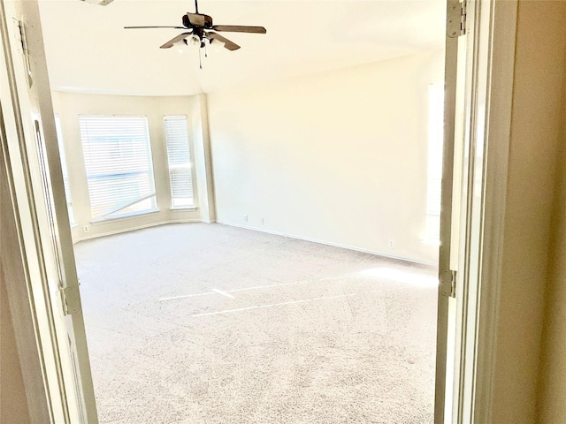 carpeted spare room with ceiling fan