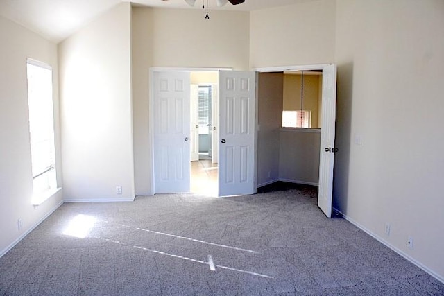 unfurnished bedroom with lofted ceiling, ceiling fan, and carpet