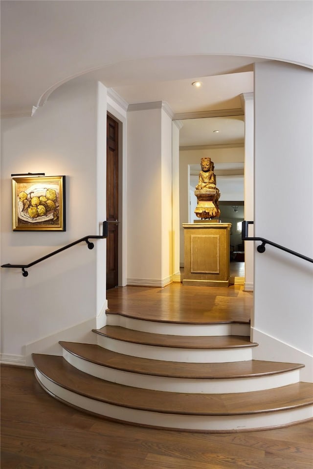 stairway with crown molding and hardwood / wood-style flooring