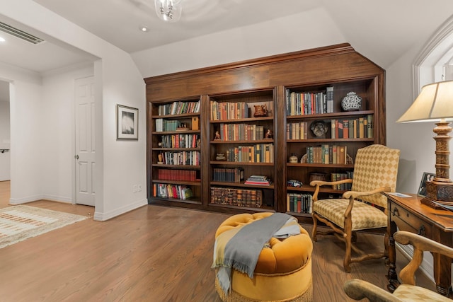 living area with wood-type flooring and vaulted ceiling