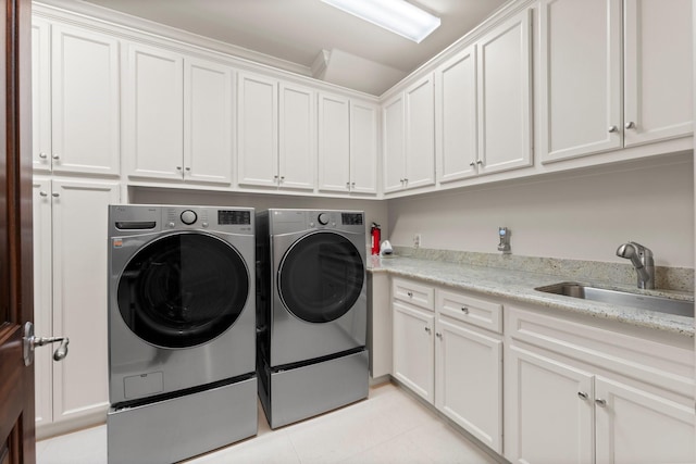 washroom featuring cabinets, washing machine and dryer, and sink