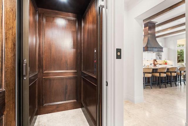 room details featuring beamed ceiling, island range hood, and elevator