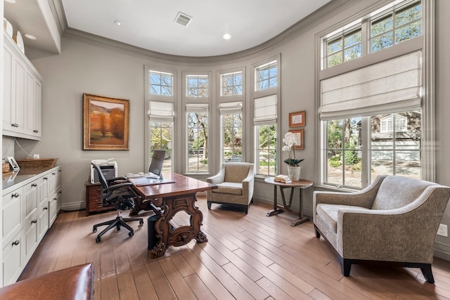 office with crown molding, a high ceiling, and hardwood / wood-style flooring