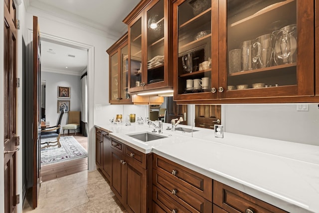 bar with ornamental molding, sink, and light tile patterned floors