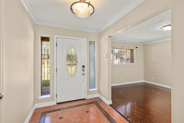 entrance foyer featuring ornamental molding, hardwood / wood-style floors, and a textured ceiling