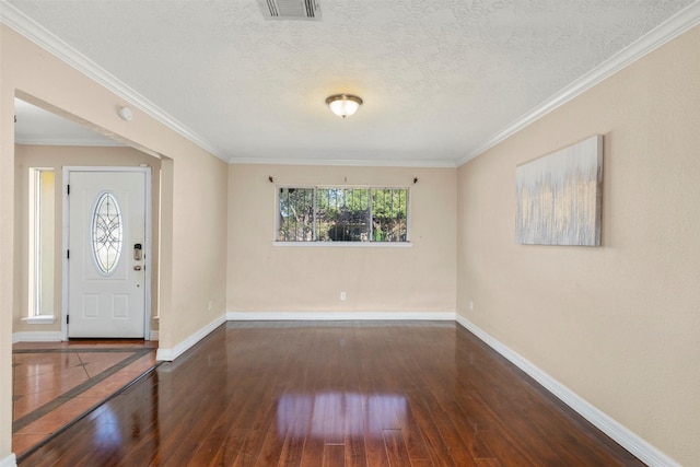 foyer featuring dark wood-type flooring, ornamental molding, and a textured ceiling