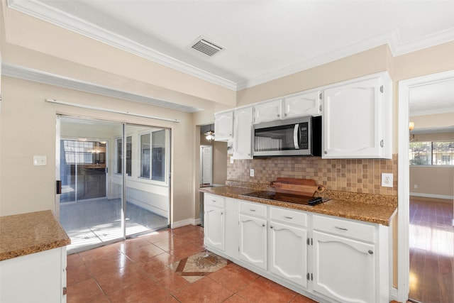 kitchen with crown molding, white cabinetry, tasteful backsplash, light tile patterned flooring, and black electric cooktop