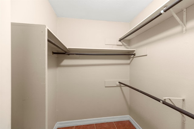 spacious closet featuring dark tile patterned flooring