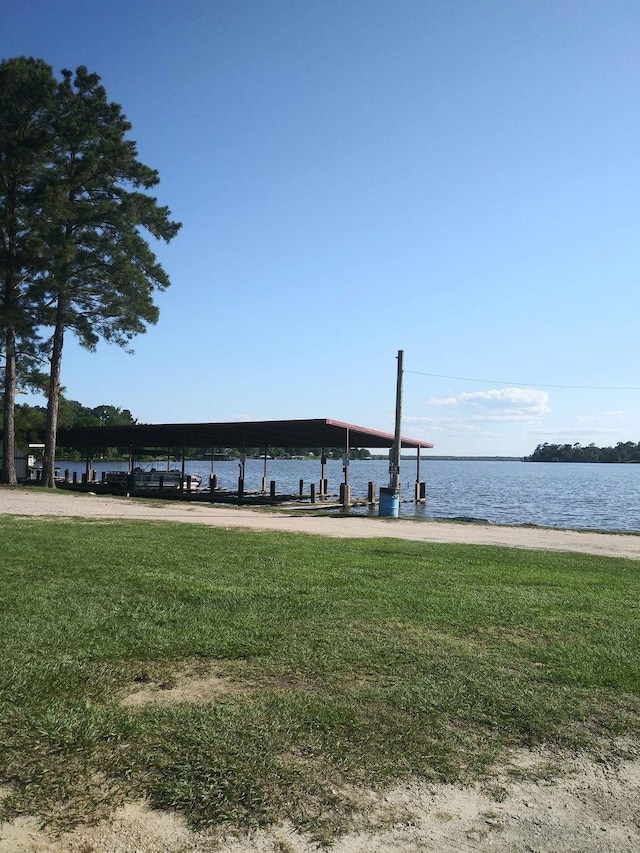 dock area featuring a lawn and a water view