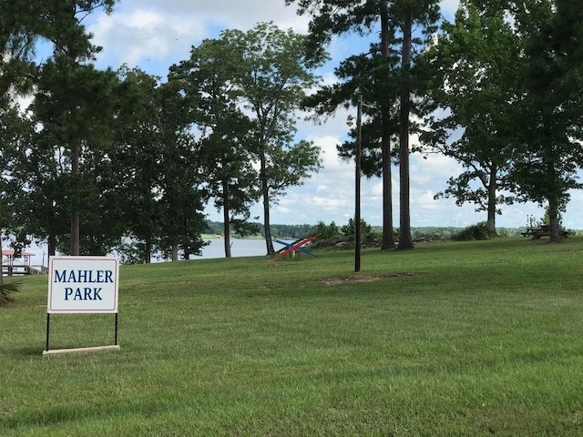 view of home's community with a water view and a yard