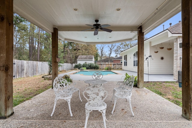 view of patio / terrace with a fenced in pool, an outdoor structure, and ceiling fan