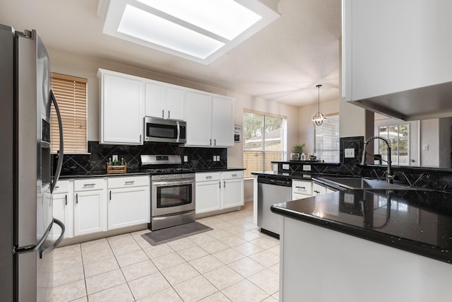 kitchen with sink, white cabinetry, decorative light fixtures, kitchen peninsula, and stainless steel appliances