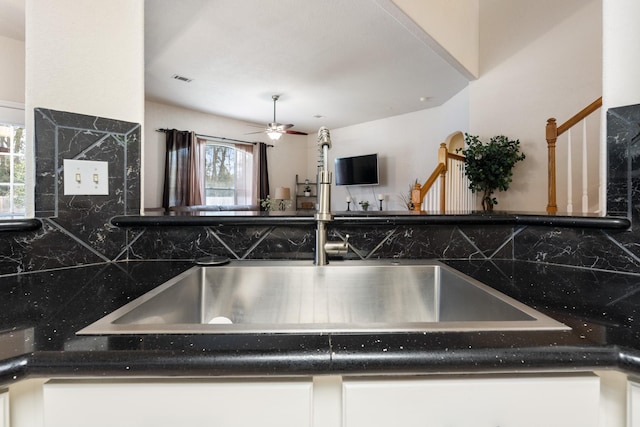 kitchen with white cabinetry, backsplash, sink, and ceiling fan