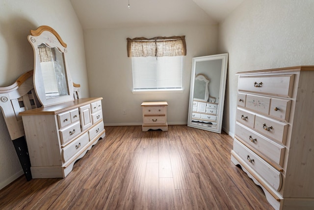 bedroom with vaulted ceiling and dark hardwood / wood-style floors