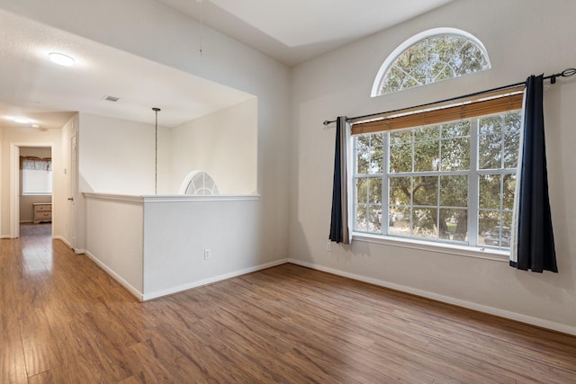 spare room with plenty of natural light and hardwood / wood-style floors