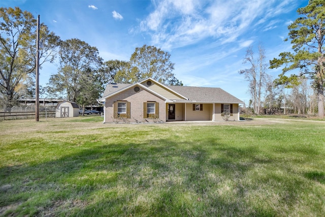 view of front facade with a front lawn, a patio, and a storage unit