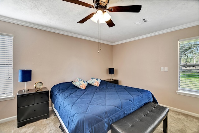 bedroom with ceiling fan, ornamental molding, light colored carpet, and a textured ceiling