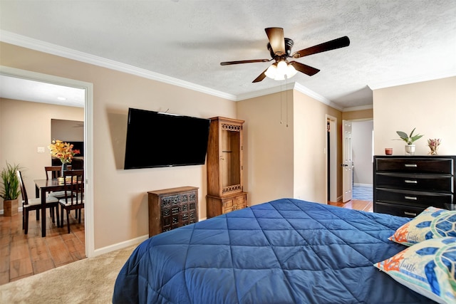 carpeted bedroom featuring ceiling fan, ornamental molding, and a textured ceiling