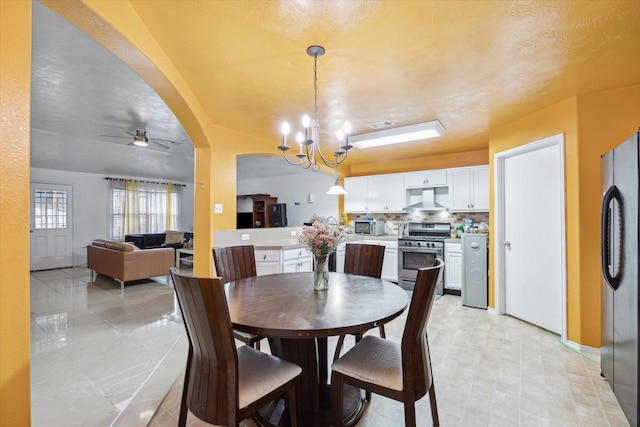 dining room with ceiling fan with notable chandelier