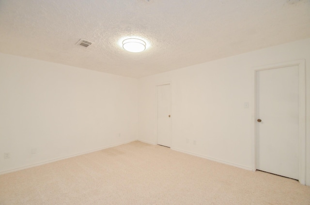 unfurnished room with light carpet and a textured ceiling