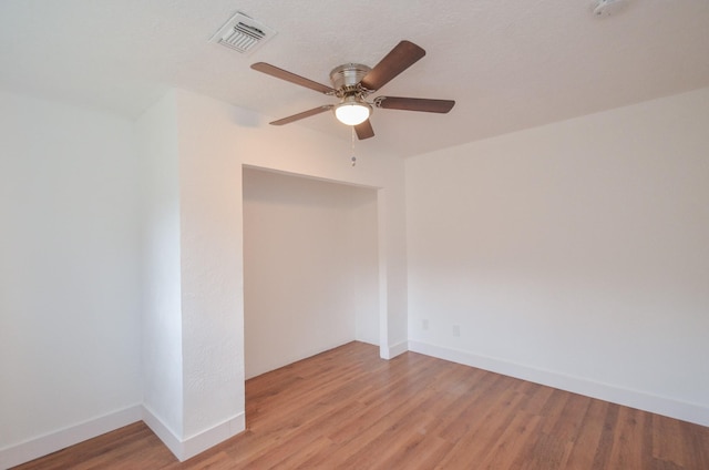 spare room with ceiling fan and light wood-type flooring