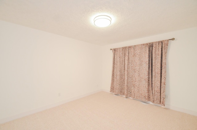 spare room featuring carpet flooring and a textured ceiling