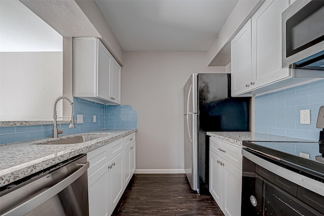 7315 Housman St, Houston, TX 77055 - kitchen with appliances with stainless steel finishes, a sink, dark wood finished floors, decorative backsplash, and white cabinetry