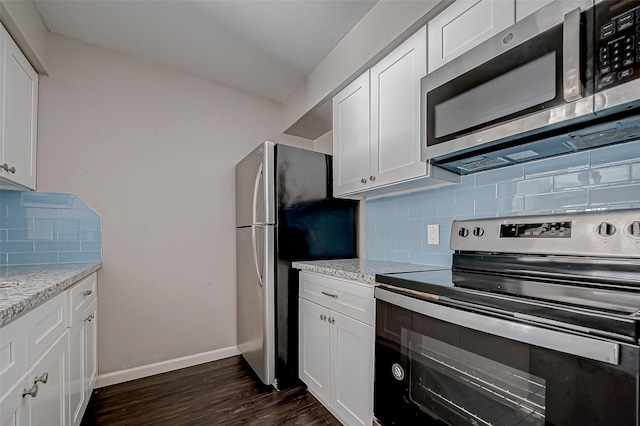 kitchen with white cabinetry, backsplash, light stone counters, and stainless steel appliances