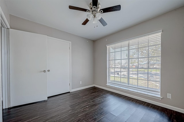 unfurnished bedroom featuring dark hardwood / wood-style flooring, ceiling fan, and a closet