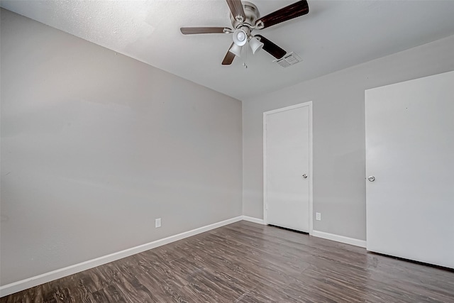 empty room with dark wood-type flooring and ceiling fan