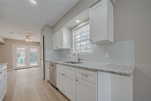 kitchen featuring tasteful backsplash, white cabinetry, dishwasher, and sink