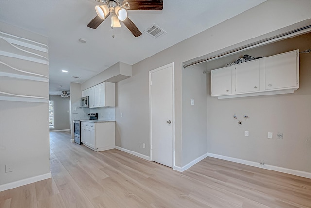 kitchen with white cabinetry, light wood-type flooring, ceiling fan, and appliances with stainless steel finishes