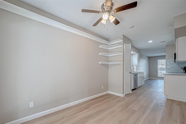 interior space with sink, dishwasher, white cabinetry, backsplash, and light wood-type flooring