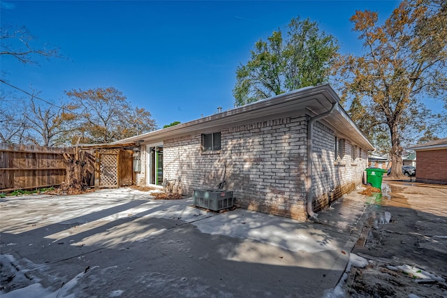 rear view of property featuring central AC unit and a patio