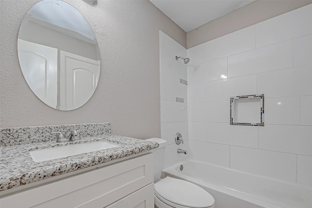 full bathroom featuring vanity, tiled shower / bath combo, and toilet