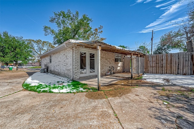 7315 Housman St, Houston, TX 77055 - back of house featuring french doors, fence, brick siding, central AC, and a patio