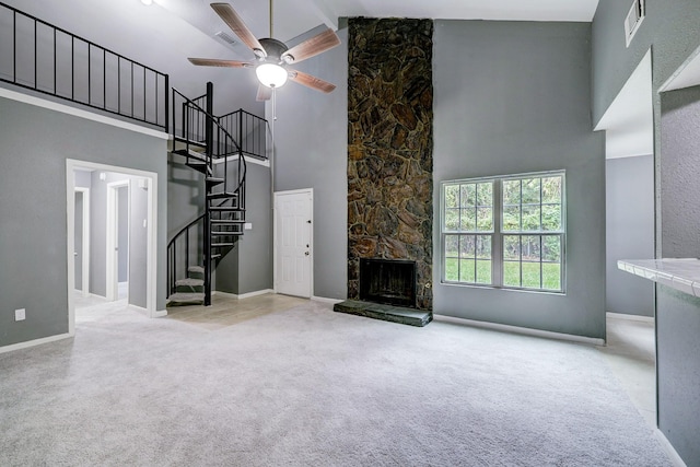 unfurnished living room with ceiling fan, a stone fireplace, light carpet, and high vaulted ceiling