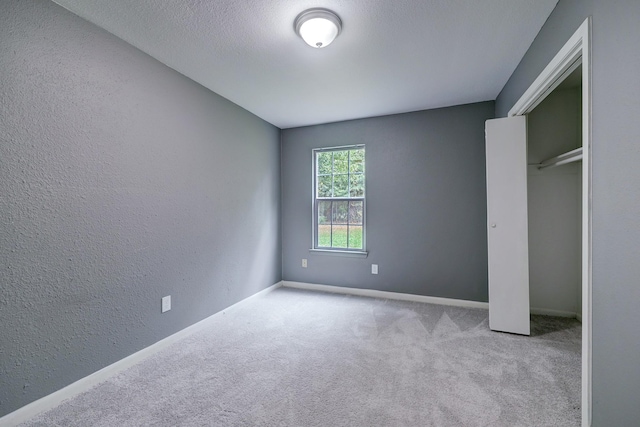 unfurnished bedroom with light carpet, a closet, and a textured ceiling