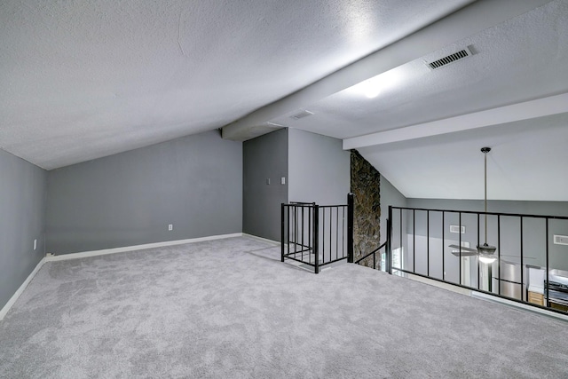 bonus room featuring carpet floors, a textured ceiling, and vaulted ceiling with beams