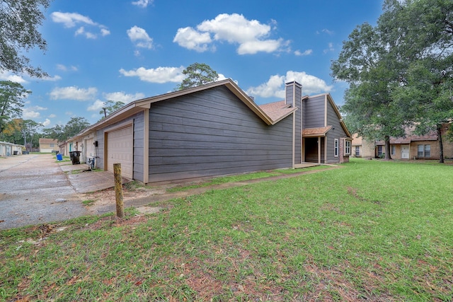 rear view of property with a garage and a yard