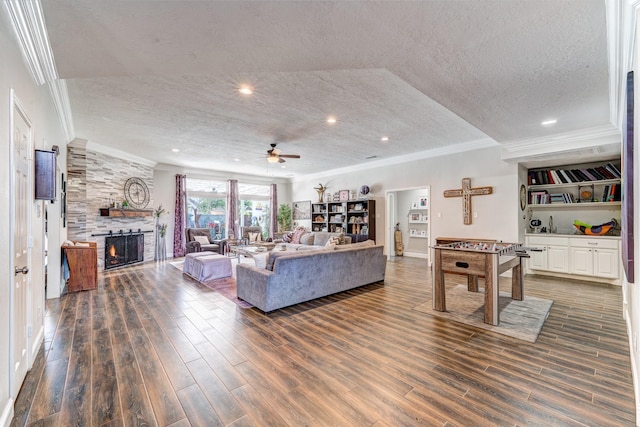 living room featuring dark wood-type flooring, a large fireplace, and a textured ceiling