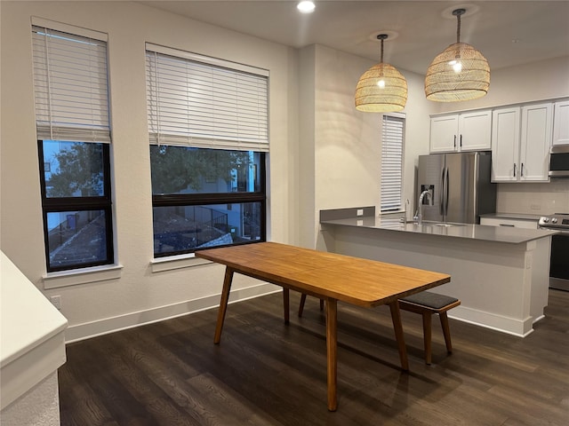 kitchen featuring pendant lighting, white cabinetry, stainless steel appliances, and kitchen peninsula