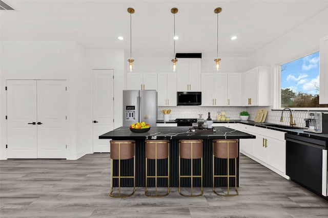 kitchen featuring a breakfast bar, sink, a center island, high quality fridge, and dishwasher