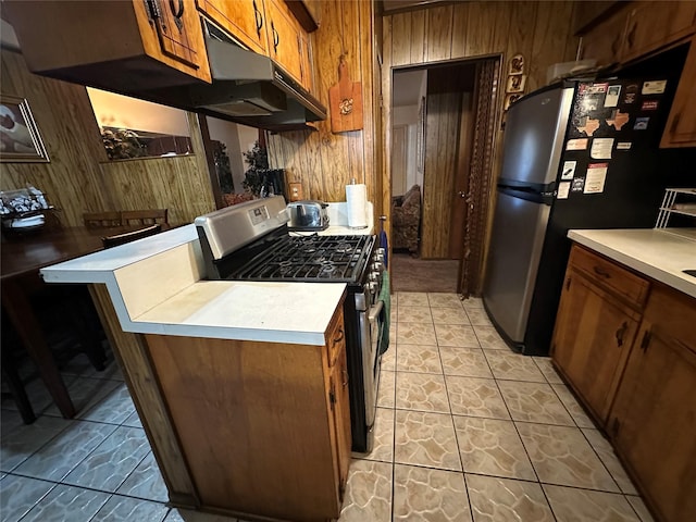 kitchen featuring wooden walls and appliances with stainless steel finishes