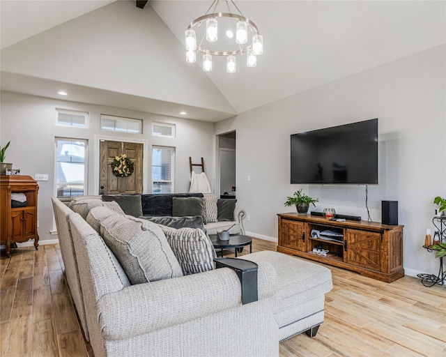 living room featuring high vaulted ceiling, light hardwood / wood-style floors, and a notable chandelier