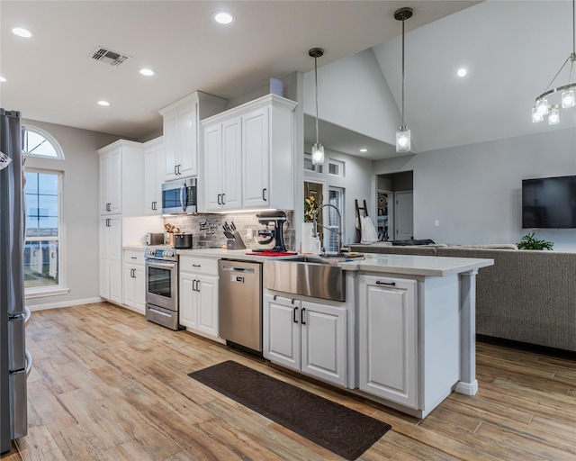 kitchen featuring white cabinetry, appliances with stainless steel finishes, sink, and pendant lighting