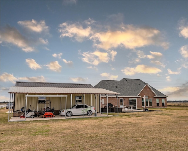 back of property with a yard and a carport